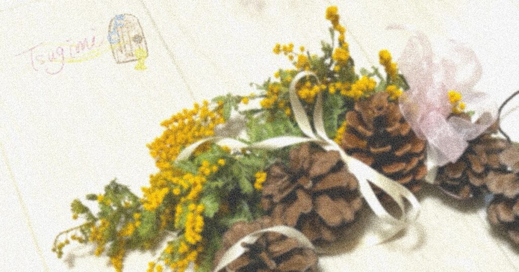松ぼっくりとミモザのリースの写真。