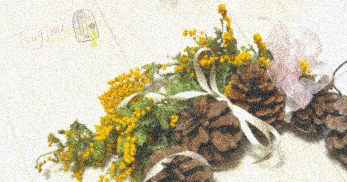 松ぼっくりとミモザのリースの写真。